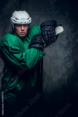 Photography Hockey player in protective clothes holds playing stick.