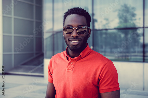 Smiling African American male in sunglasses.