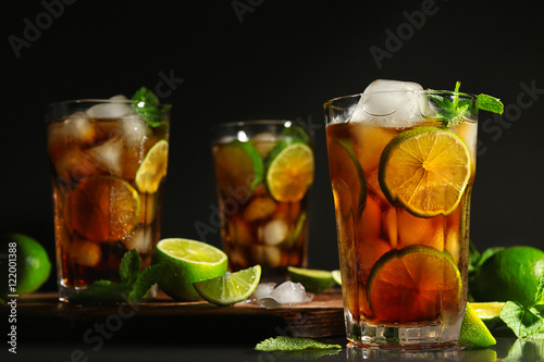 Bilde på lerret Cuba libre cocktail with lime, ice and mint on dark background