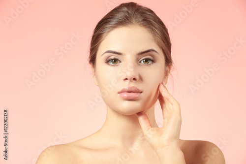 Portrait of beautiful young woman on color background