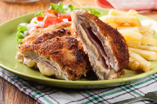 Fotografi Cutlet Cordon Bleu with pork loin served with French fries and salad