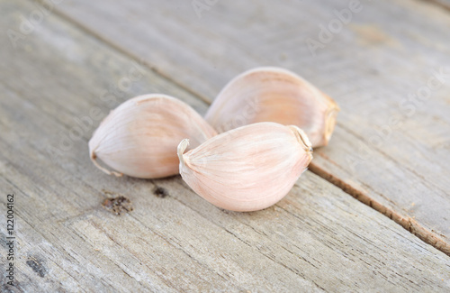 uncooked garlic with shell on wooden table