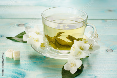 Tea with jasmine herb flower on wooden table background. 