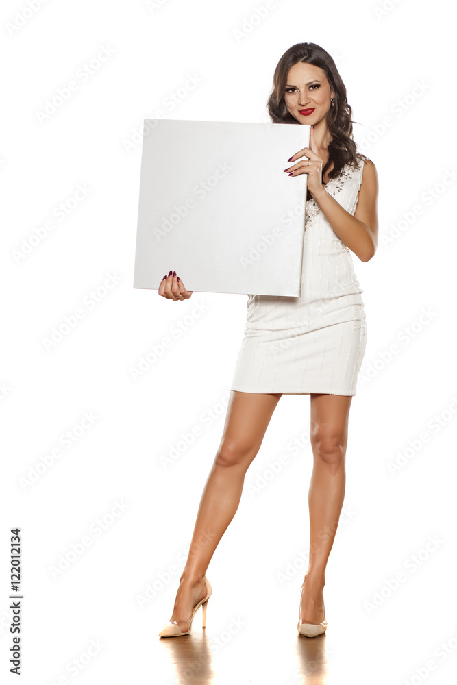 beautiful and pretty brunette in a short dress holding a blank board beautiful and pretty brunette in a short dress holding a blank board