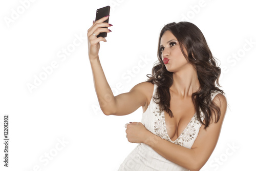elegant young woman takes selfies with her phone