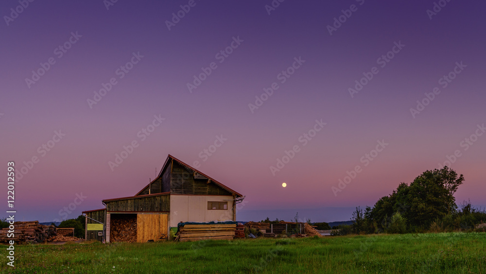 Bauernhütte auf grüner Wiese vor violettem Abendhimmel mit Mond zu sehen Bauernhütte auf grüner Wiese vor violettem Abendhimmel mit Mond zu sehen