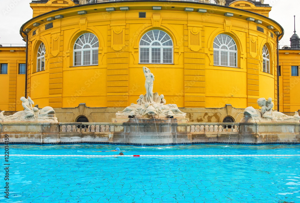 The old swimming pool with blue water decorated with sculptures