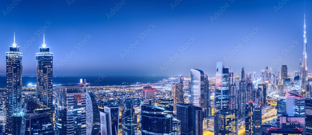 Obraz premium Panoramiczny widok z lotu ptaka na duże futurystyczne miasto nocą. Business Bay, Dubaj, Zjednoczone Emiraty Arabskie. Nocna panorama.