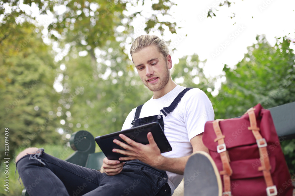 Obraz premium Handsome young man sitting at the park