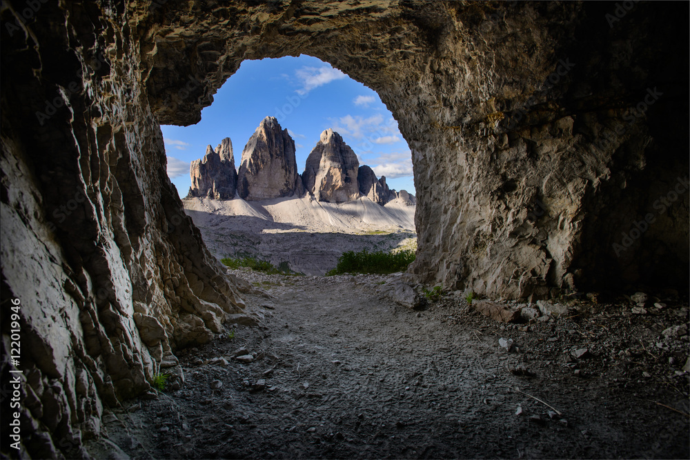 View of Tre Cime from a cave.  Interesting perspective of a famous mountain in dolomites. Italy. Hiking paradise. Mountaineering. Vacation in Europe