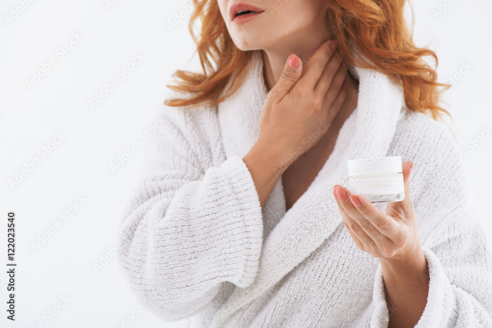 Senior lady treating her skin with moisturizer Senior lady treating her skin with moisturizer