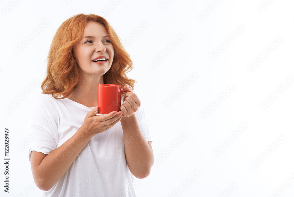 Dreamful middle-aged lady relaxing with cup of beverage Dreamful middle-aged lady relaxing with cup of beverage
