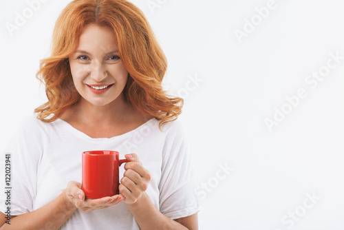 Joyful senior lady enjoying hot drink