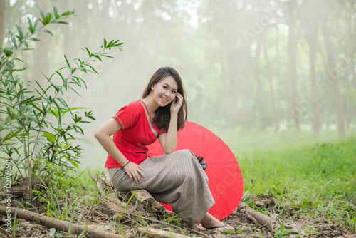 Beautiful Thai girl in Lanna traditional costume with red umbrel photo