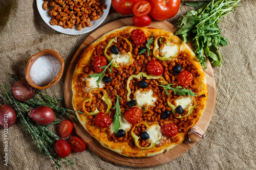 Pizza bolognese on a wooden board.