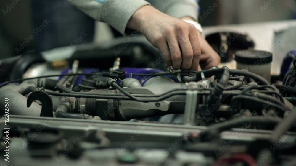 Mechanic customizes the engine in the car, close up Mechanic customizes the engine in the car, close up