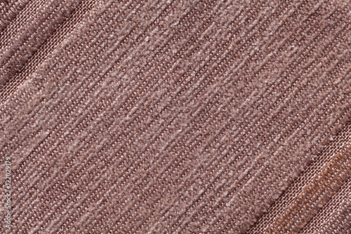 Light brown background of a knitted textile material. Fabric with a striped texture closeup.