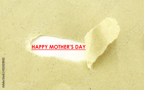 Text HAPPY MOTHER'S DAY appearing behind torn light brown envelo photo