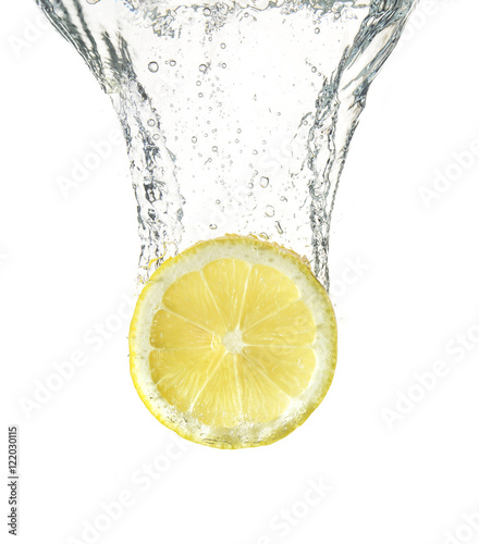 slice of ripe lemon falling into water