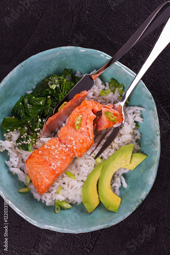 Salmon with spinach and avocado. Rice as a garnish. View from above, top studio shot