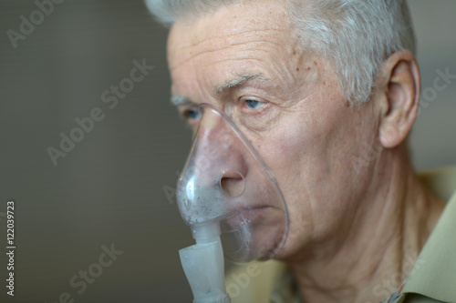 Elder man making inhalation