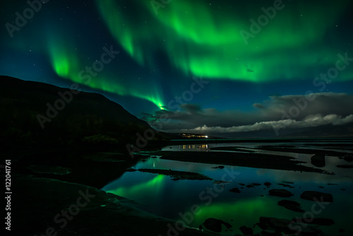 Fotografia Northern lights dancing over calm lake in Abisko national park