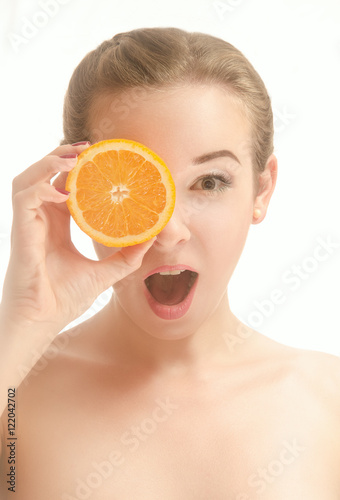 Surprised beautiful woman with a slice of orange