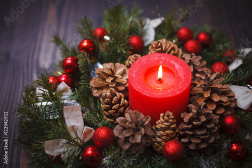 Decorated Christmas wreath with a candle close-up