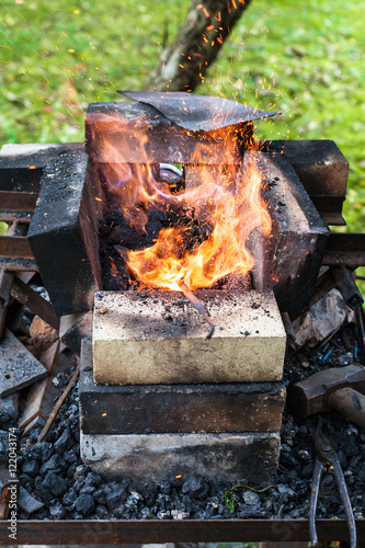 iron rod is heated in brick forging furnace photo