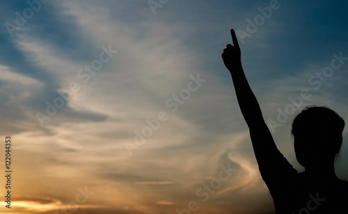silhouette of woman pointing with finger in sky