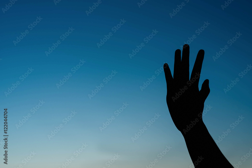silhouette of woman two hands on the sky at sunset.
