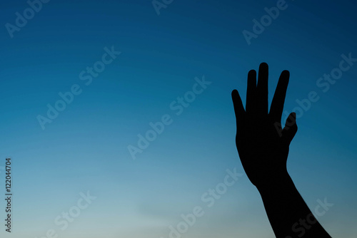 silhouette of woman two hands on the sky at sunset.
