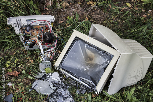 broken white computer lying on the grass