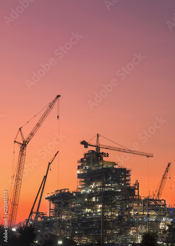 Oil refinery construction in silhouette