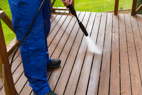 cleaning wooden terrace with high pressure washer photo
