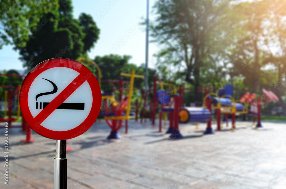 No smoking sign with colorful exercise equipment in public park