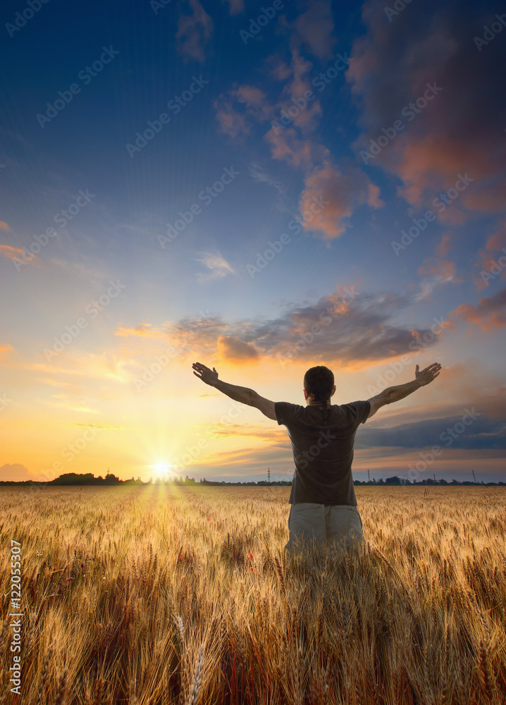 Man with raised hands stay in a wheat field Man with raised hands stay in a wheat field