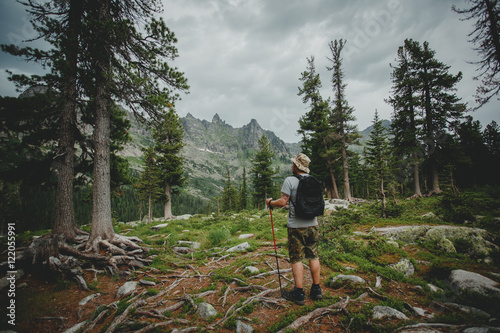 Man hiking in the mountains with a backpack in wildlife nature
