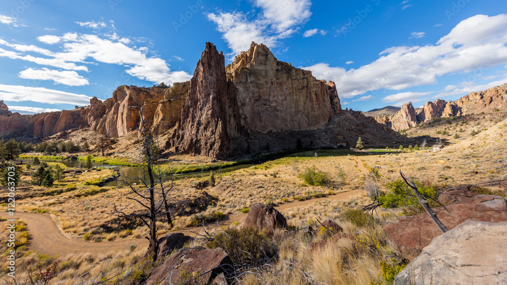 The road among the dry grass. The beautiful landscape of cliffs. Smith Rock state park, Oregon