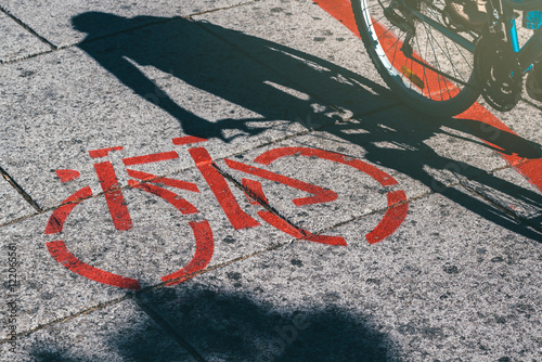 Shadow of female biker and bicycle route road marking
