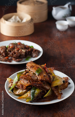 Twice cooked pork - traditional Chinese dish from Sichuan region . 
Spicy cumin lamb - traditional Uyghur dish  from Xinjiang region in China.  photo