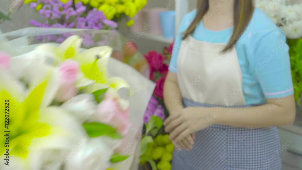 Florist woman giving a beautiful flower bouquet to a customer by her hand Florist woman giving a beautiful flower bouquet to a customer by her hand