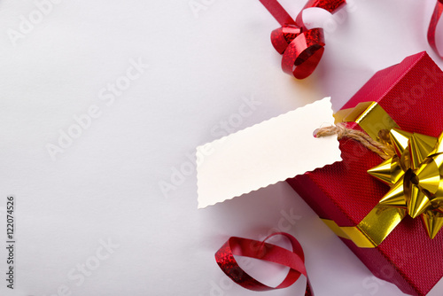 Red gift box with golden ribbon and label hanging