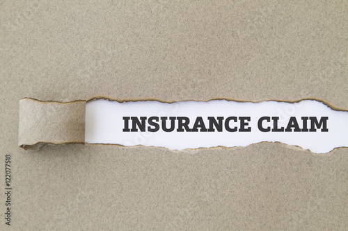 Foto INSURANCE CLAIM written under torn paper.