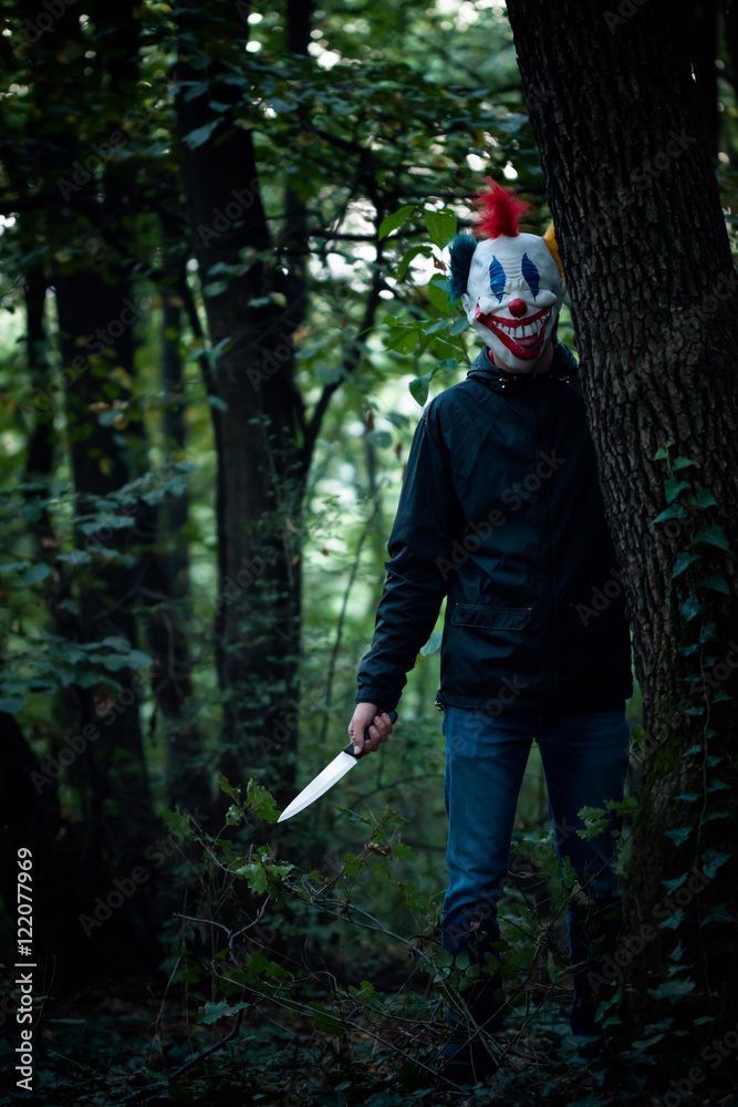 scary clown with knife in wood Stock Photo | Adobe Stock