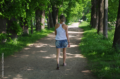 Beautiful young woman walking in summer park © evolutionnow