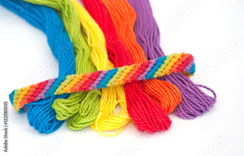 Colorful yarn for making wristbands for children, with one ready made shown