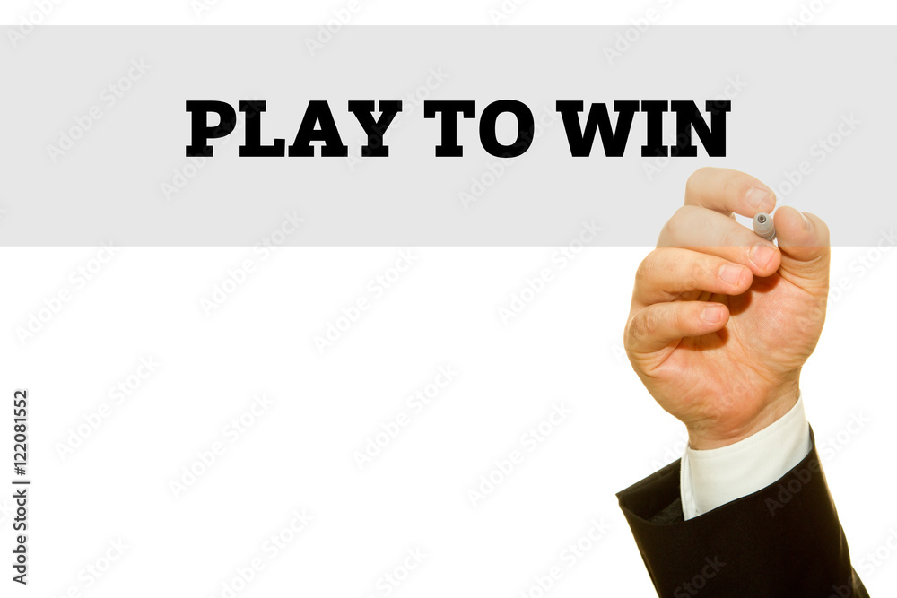 Businessman hand writing PLAY TO WIN message on a transparent wipe board.