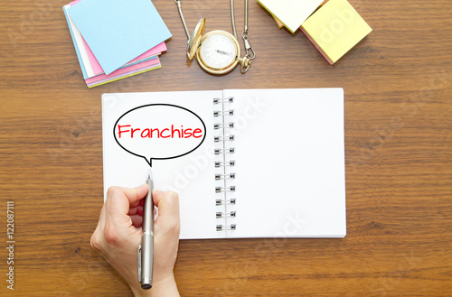 Fotografía Hand writing FRANCHISE word on a notebook with pen.