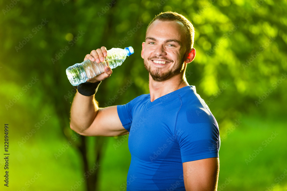 Happy young man drinking water after workout outdoors stock photo (124775)  - YouWorkForThem